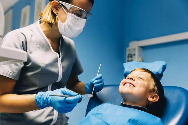 Dentistas com um paciente durante uma intervenção dentária para menino . — Fotografia de Stock