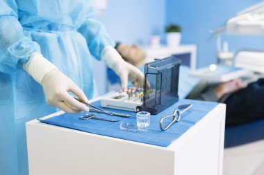 Diş kliniğinde diş araçları tutan el detay.