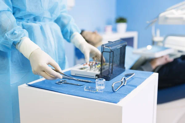 Detalhe de mão segurando ferramentas dentárias na clínica odontológica . — Fotografia de Stock