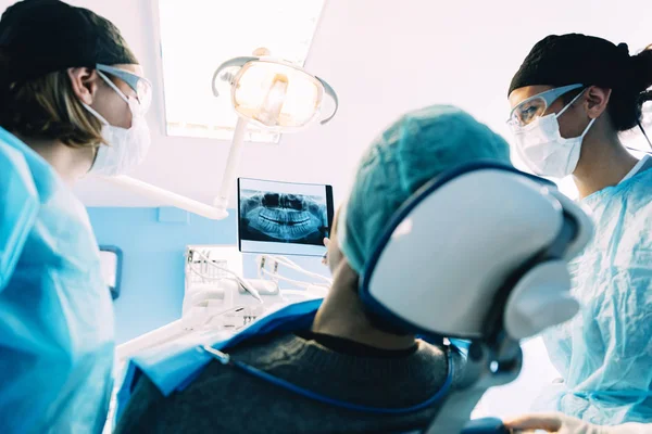 Dokter praat met haar patiënt en het onderwijzen van een radiografie. — Stockfoto