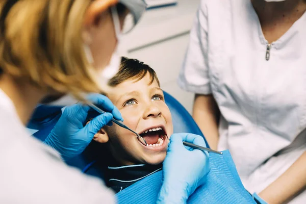 Dentistes avec un patient lors d'une intervention dentaire chez un garçon . — Photo