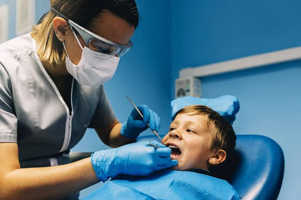Zahnärzte mit einem Patienten während eines zahnärztlichen Eingriffs an Jungen. — Stockfoto