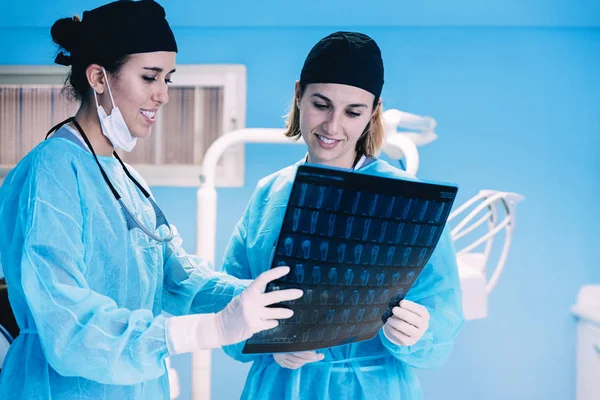 Dentista mostrando algo para sua colega na imagem de raio-x . — Fotografia de Stock