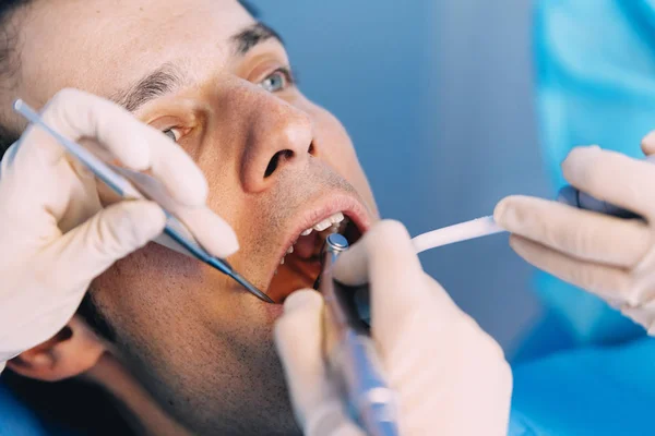 Dentistes avec un patient lors d'une intervention dentaire . — Photo