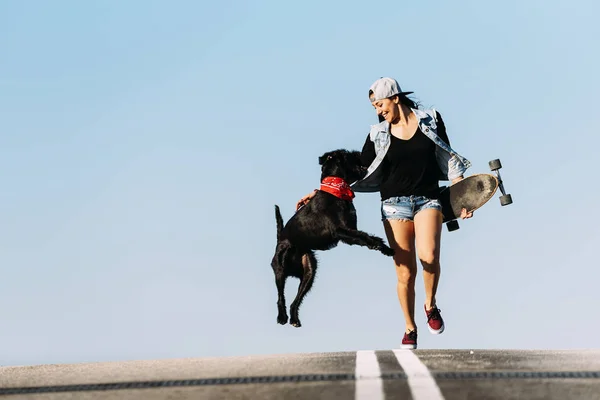 Jovem bonita brincando com seu cão . — Fotografia de Stock