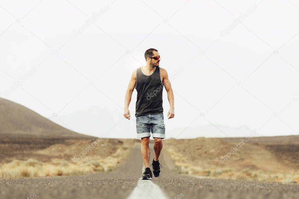 Handsome man walking along the desert.
