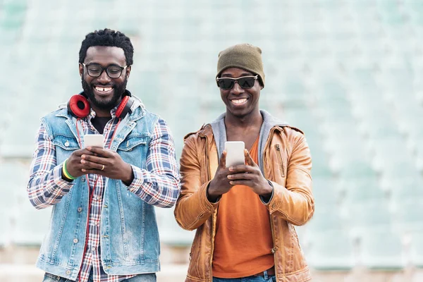Dois amigos de raça negra se divertindo com celular . — Fotografia de Stock