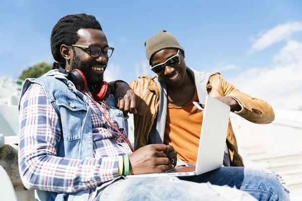 Двоє друзів чорної раси розважаються з ноутбуком . — стокове фото