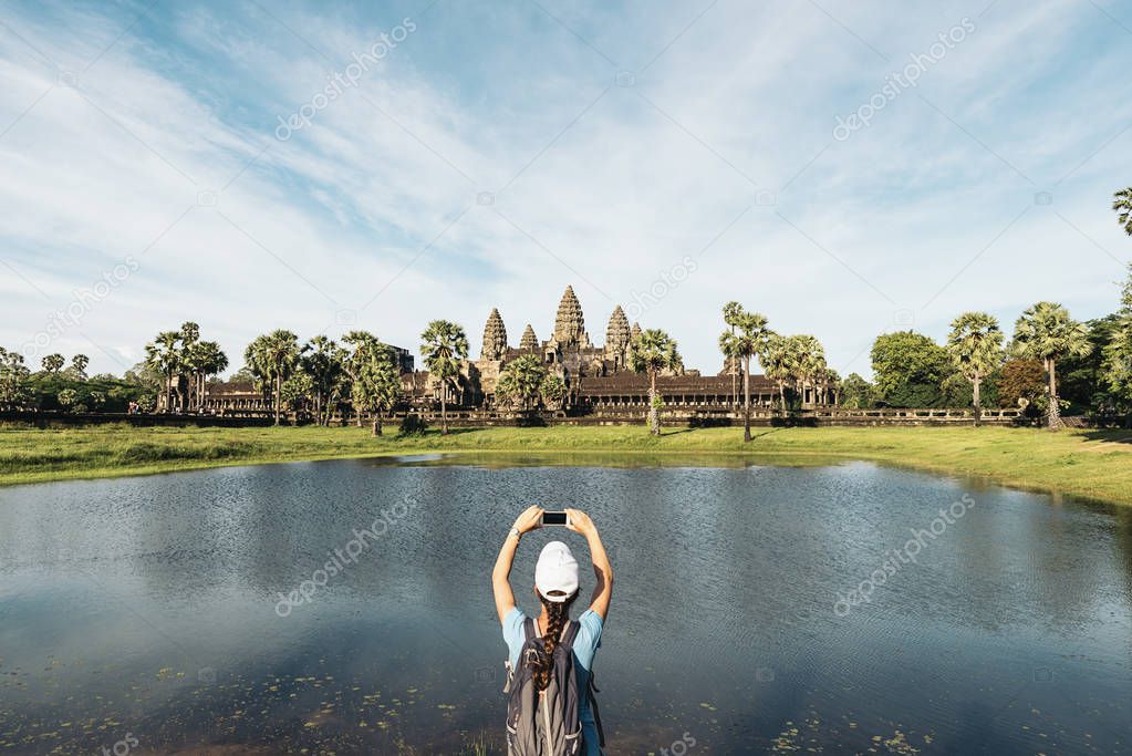 Woman taking picture to Angkor Wat Temple.