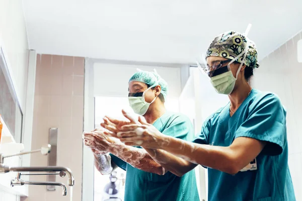 Paar Chirurgen waschen sich vor der Operation die Hände. — Stockfoto
