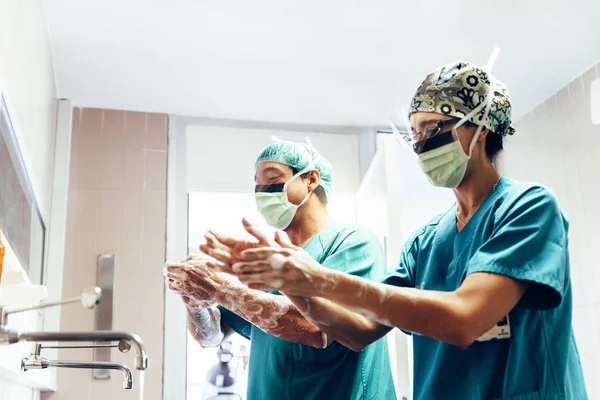 Pareja de cirujanos lavándose las manos antes de operar . —  Fotos de Stock