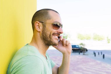 Yakışıklı genç adam cep telefonu ve sabit vites bisiklet.