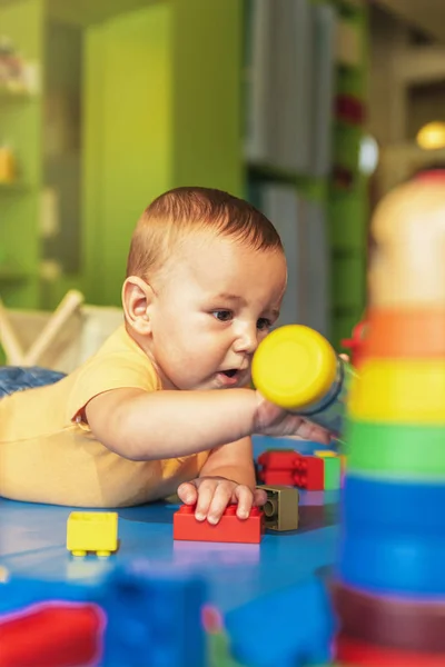 Happy baby playing with toy blocks in the kindergarten. — Stock Photo, Image