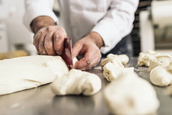 Baker kneading dough in a bakery. — Stock Photo, Image