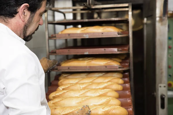Panettiere che fa il pane in una panetteria . — Foto Stock