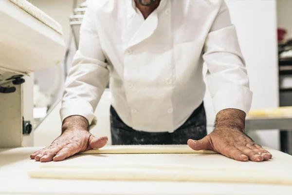 Bäcker knetet Teig in einer Bäckerei. — Stockfoto