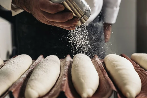 Padeiro fazendo pão em uma padaria . — Fotografia de Stock