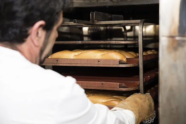 Baker, pečení chleba v pekárně. — Stock fotografie
