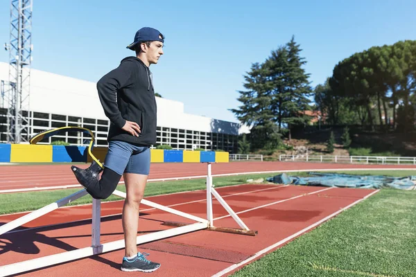 Atleta hombre discapacitado estiramiento con prótesis de pierna . — Foto de Stock