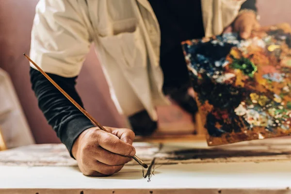 Viejo artista pintando óleos en su estudio. Concepto de artista . — Foto de Stock