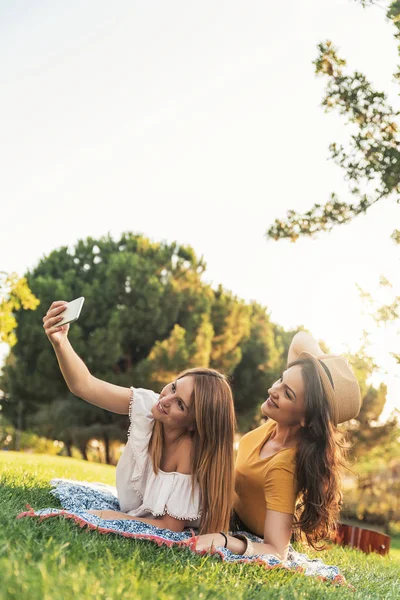 Hermosas mujeres tomando un retrato de selfie en el parque . — Foto de Stock
