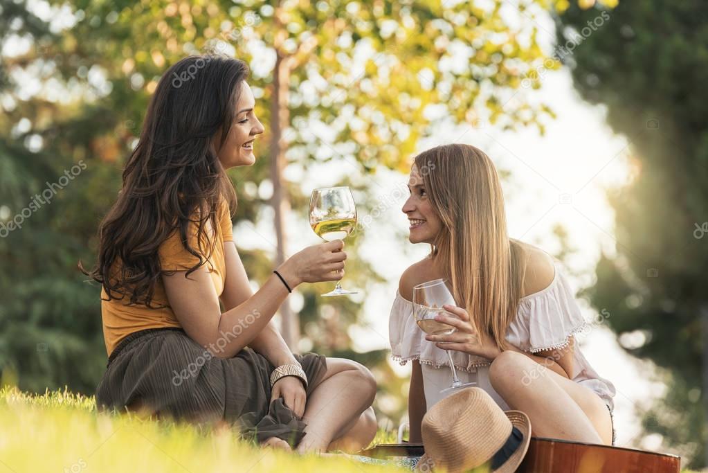 Beautiful women drinking wine in the park.