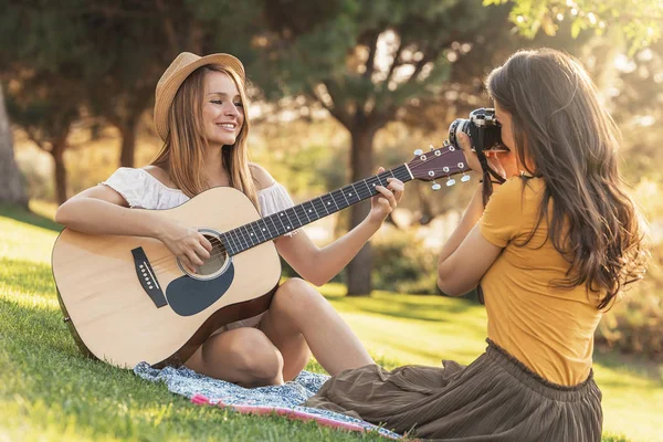 Mulheres bonitas se divertindo tocando guitarra e câmera de fotos no th — Fotografia de Stock