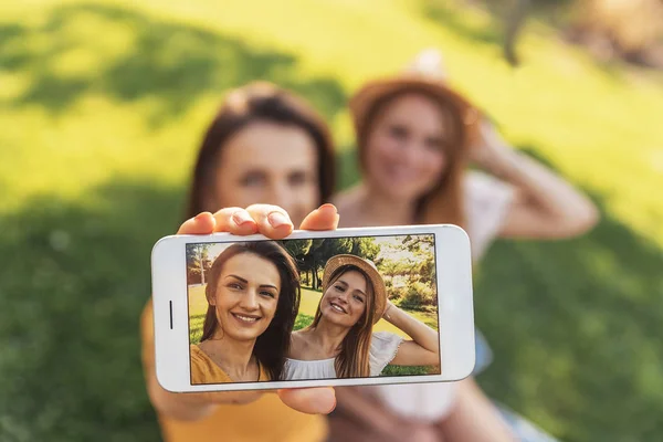 Hermosas mujeres tomando un retrato de selfie en el parque . — Foto de Stock