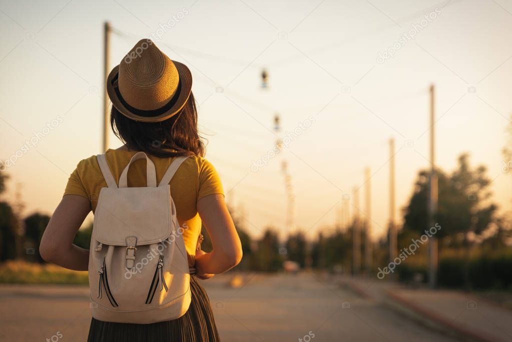 Back view of young woman looking the road. 