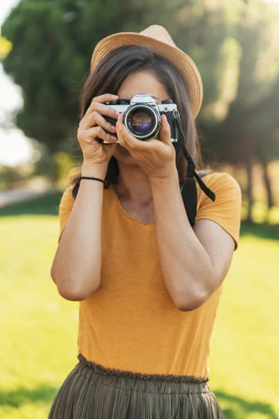 Mujer joven usando una cámara para tomar fotos . — Foto de Stock