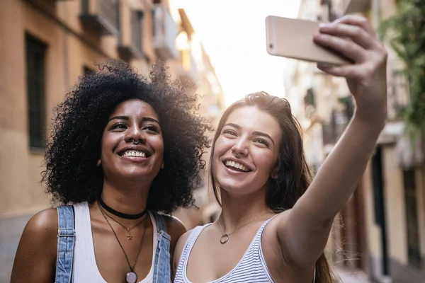 Hermosas mujeres tomando un autorretrato en la calle . — Foto de Stock