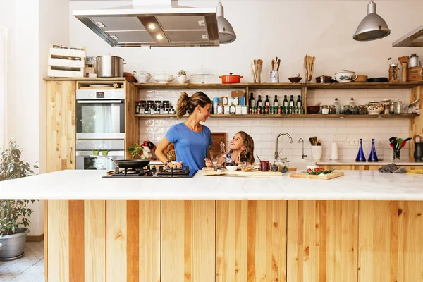 Niña cocinando con su madre en la cocina. — Foto de Stock