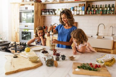 Little sisters ile annesi mutfakta yemek.