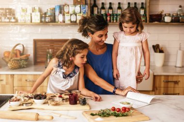 Little sisters ile annesi mutfakta yemek.