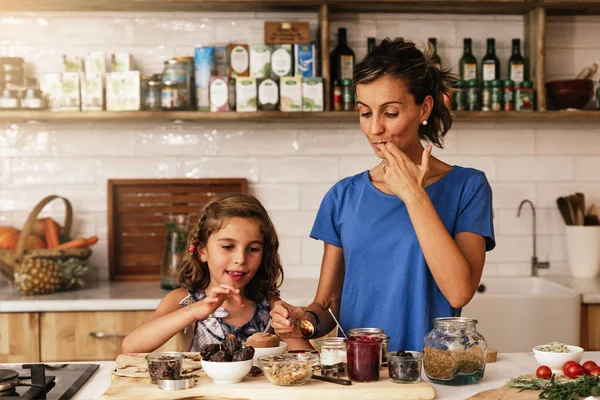 Malá dívka vaří se svou matkou v kuchyni. — Stock fotografie