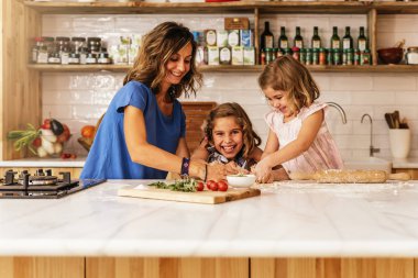 Little sisters ile annesi mutfakta yemek.