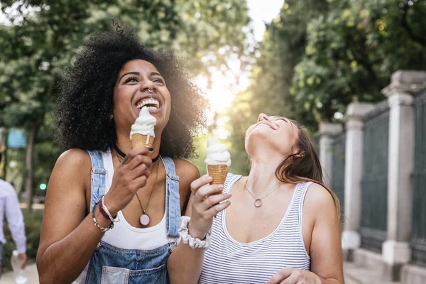 Piękne kobiety jedzenie jeden lody na ulicy. — Zdjęcie stockowe