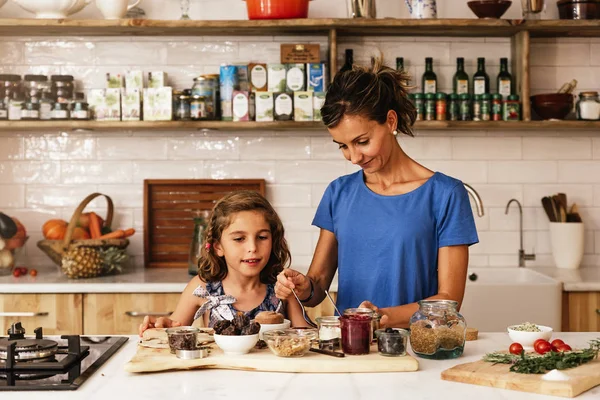 Little girl cooking with her mother in the kitchen. — Stock Photo, Image