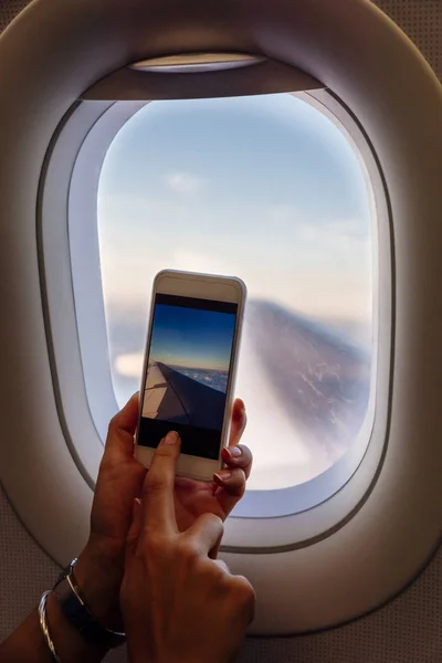 Gros plan des mains de la femme prenant des photos dans l'avion . — Photo