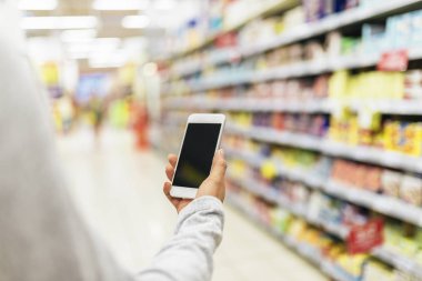 Onun mobil süpermarkette kullanarak kadının yakın çekim.