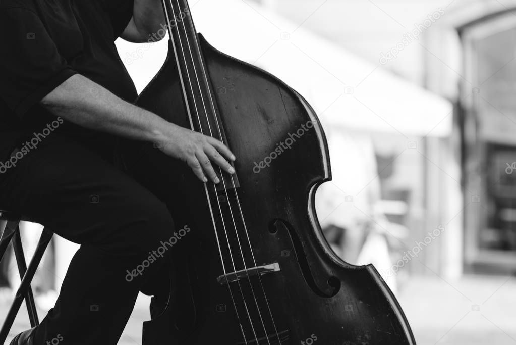 Musician playing double bass at the street. 