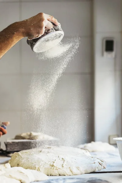 Ruka muže Baker šíření mouky do těsta. — Stock fotografie