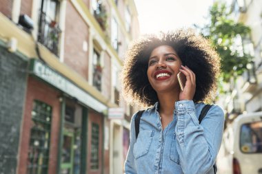 Güzel afro Amerikalı kadın sokakta telefon kullanma.