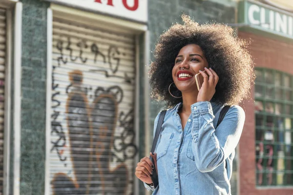 Mulher afro-americana bonita usando celular na rua . — Fotografia de Stock