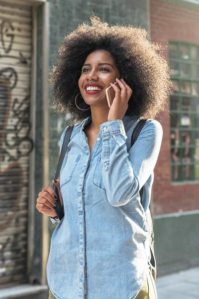 Mulher afro-americana bonita usando seu celular na rua . — Fotografia de Stock