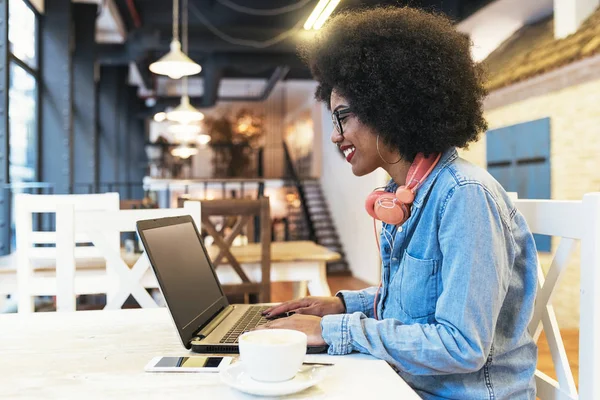 Όμορφη afro Αμερικανός γυναίκα χρησιμοποιώντας κινητό και φορητό υπολογιστή στο το cof — Φωτογραφία Αρχείου