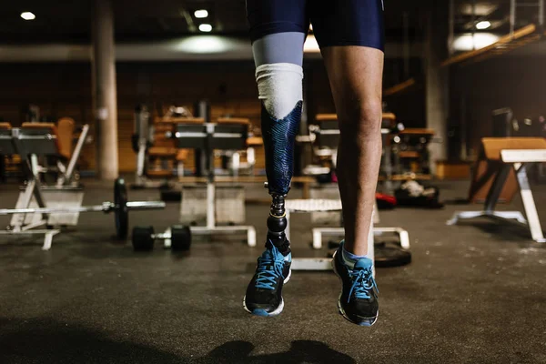 Primer plano de la pierna de prótesis de un joven entrenando en el gimnasio . — Foto de Stock