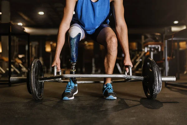 Behinderter junger Mann trainiert im Fitnessstudio. — Stockfoto