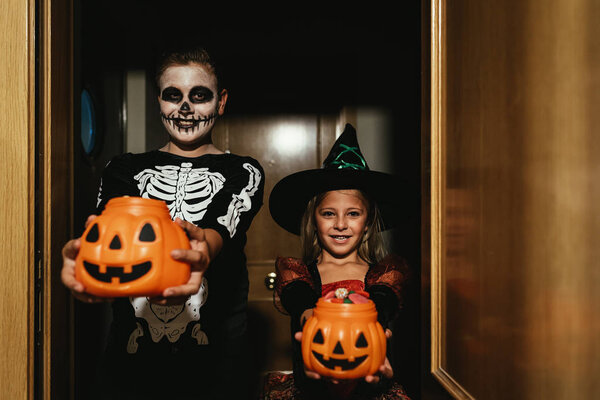 Happy children disguised saying trick or treating.