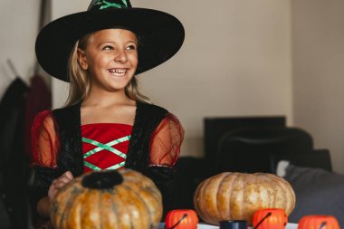 Güzel kız bir kabak evde dekorasyon cadısını kılığında.